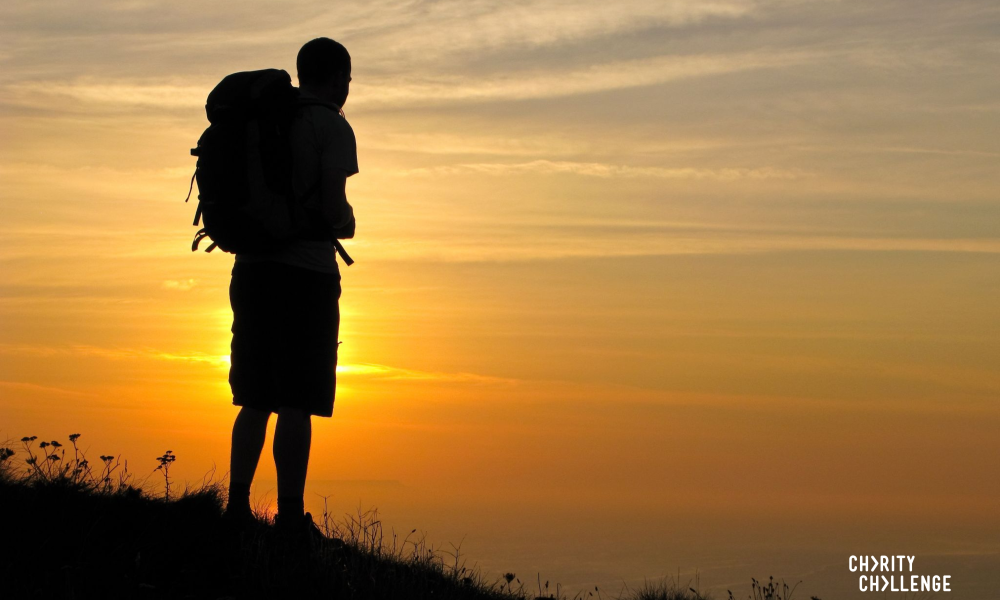 Hiker looking out at the sunrise on a mountain.