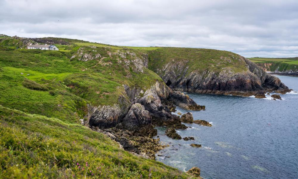 Waves crash against the Pembrokeshire coastline near Câr-Y-Môr seaweed farm in Wales.