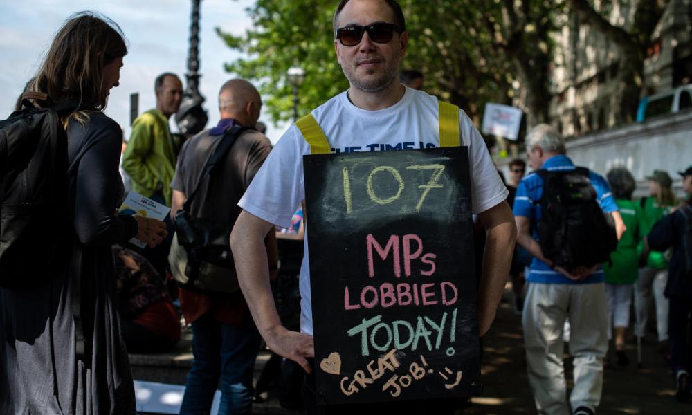Thieo Gott updates a sandwich board with the number of MP's lobbied so far in Westminster, London