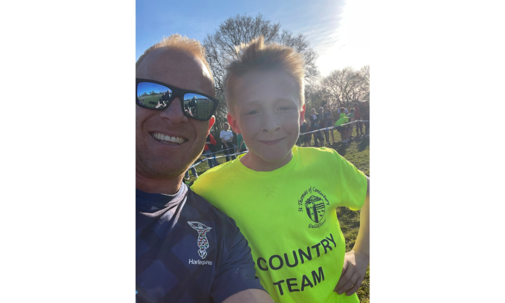 A man in sunglasses and a small boy in a yellow shirt smiling