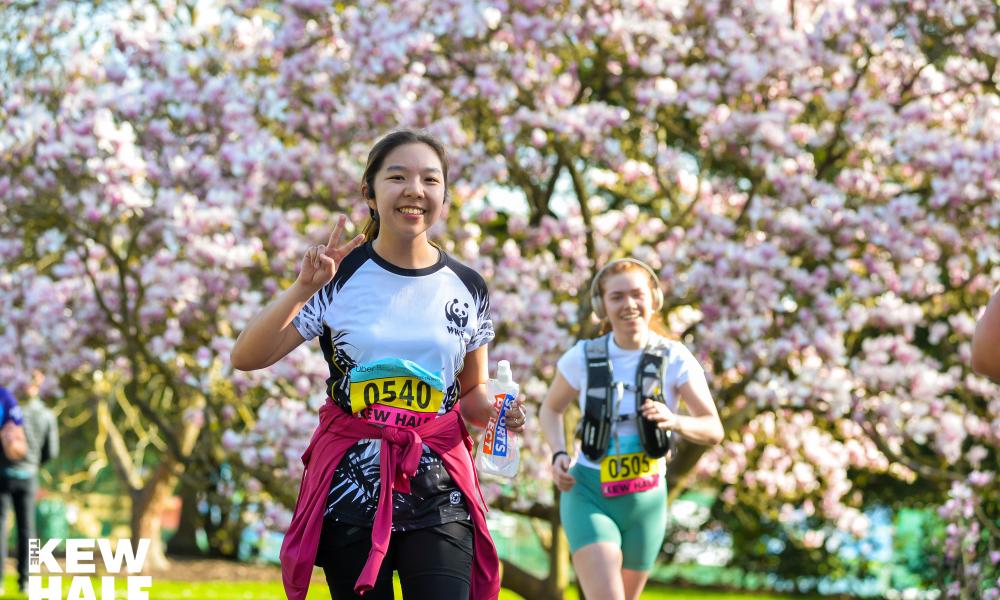 Runner in Kew Gardens with tree blossoms