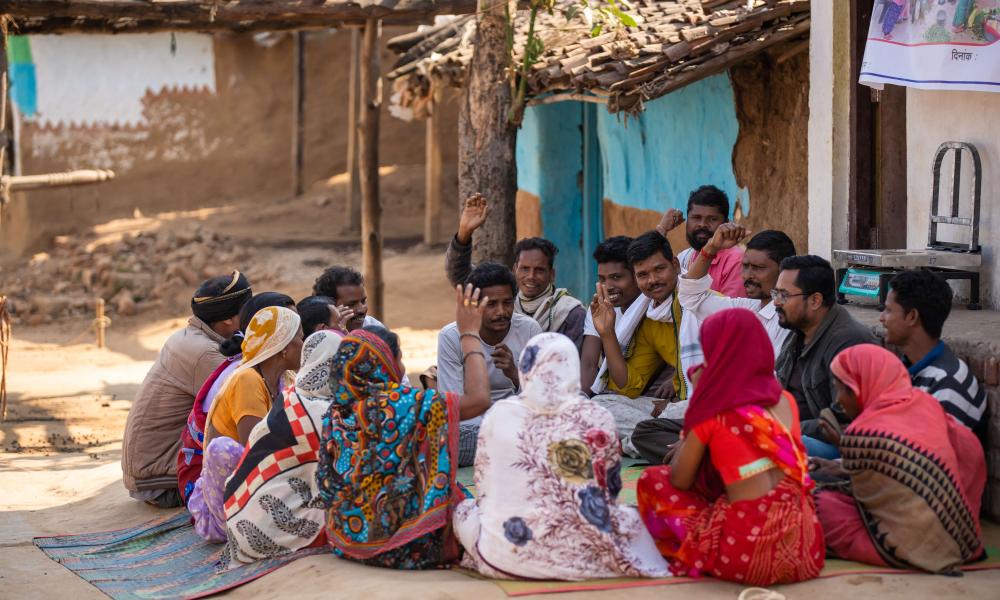 A group of people sat together in a community in India