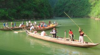 Tujia boatmen steering canoes through a gorge