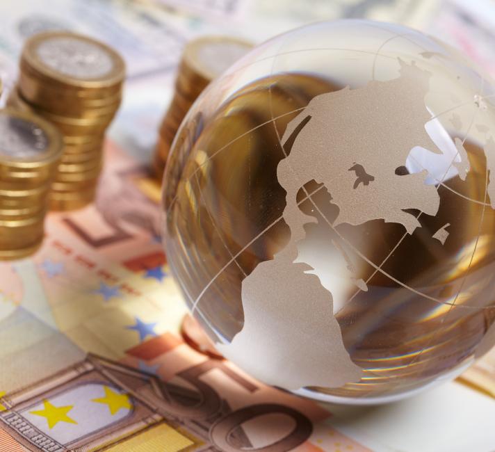 Currency and planet on a table representing global economy - © Shutterstock