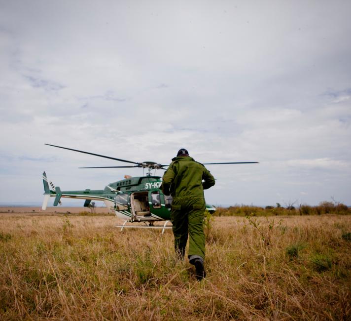 Vets boarding helicopter to go and dart rhinos