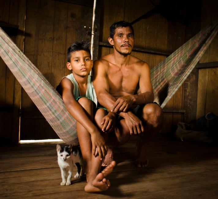 A man and boy sit on a hammock in CazumbÌÁ-Iracema Extractive Reserve in Acre, Brazil. The CazumbÌÁ-Iracema Extractive Reserve is part of the Amazon Region Protected Area program.