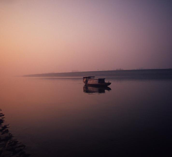 A fishing boat on Dongting Lake at dawn. Hunan Province China.
