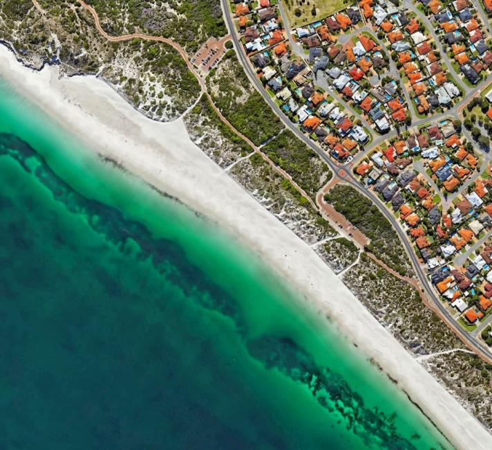 An aerial photograph of houses along the coastline.