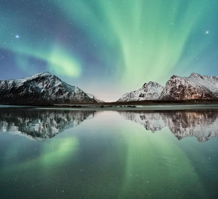 The northern lights above snowy mountains