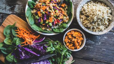 Healthy looking bowl of food including carrots, cabbage, salad leaves and quinoa.