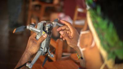 Close up of an Indigenous man holding a drone