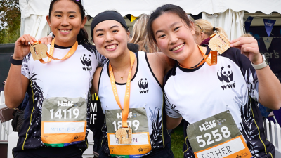 Three WWF runners at the Royal Parks Half Marathon showing their medals