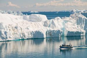 A fishing boat sails through Icebergs