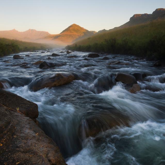 The Pholela River flows over a small rapid at dawn within the uKuhlamba World Heritage site and location of the Deakensberg Mountain catchment.