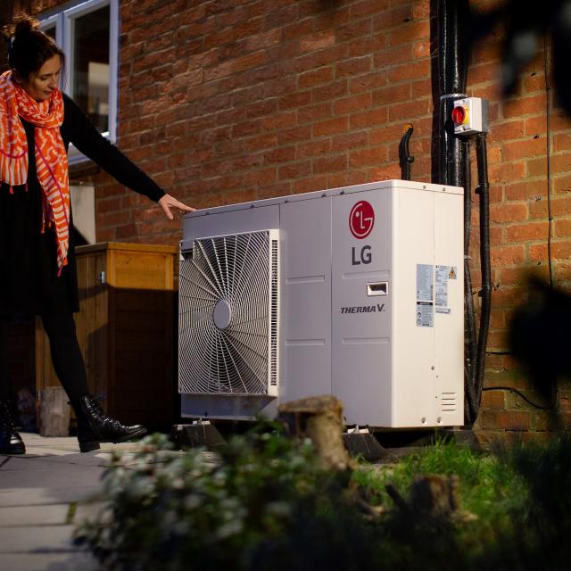 Yasmine Prichard with her air source heat pump at her home in Guildford, Surrey.
