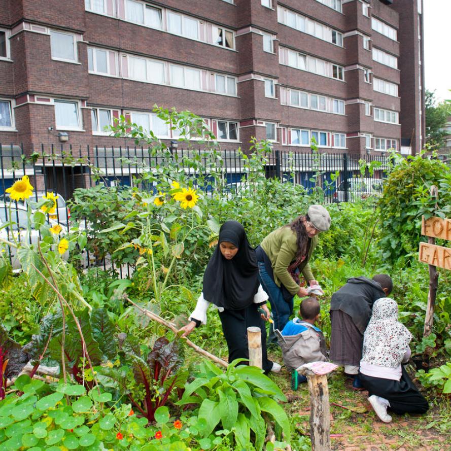 People working and looking around in Evelyn Community Gardens, Deptford, London, England, UK