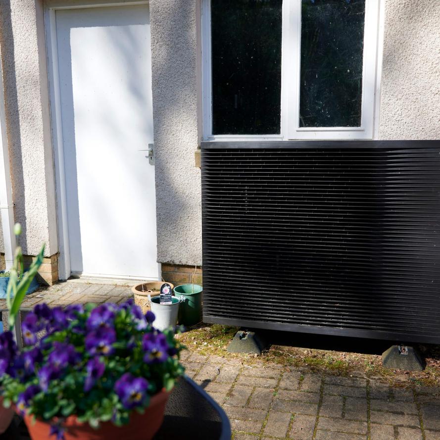 Daikin heat pump with flowers in the forefront of the image