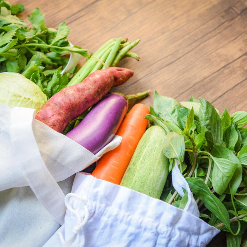 Fresh vegetables, sitting in an organic and cotton fabric bag.