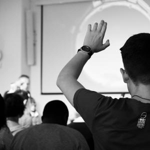 man raising his hand in a meeting