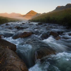 The Pholela River flows over a small rapid at dawn within the uKuhlamba World Heritage site and location of the Deakensberg Mountain catchment.