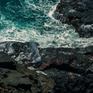 Waves crash against rocks at Baía dos Porcos, Fernando de Noronha Island, Brazil 