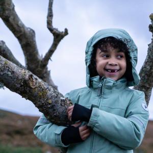Alexander Thompson Byer son in a tree with a blue jacket on