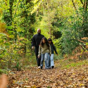 Family walking in woods wearing Pangaia jumpers