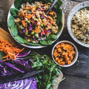 Healthy looking bowl of food including carrots, cabbage, salad leaves and quinoa.