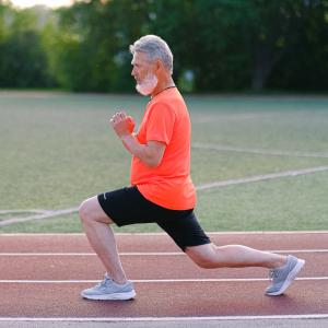 Man doing lunges on a race track